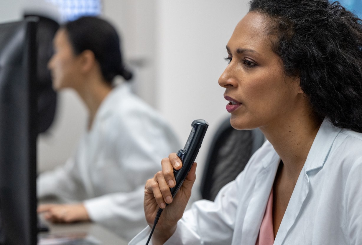 Female radiologist dictation recorder looking at MRI scan